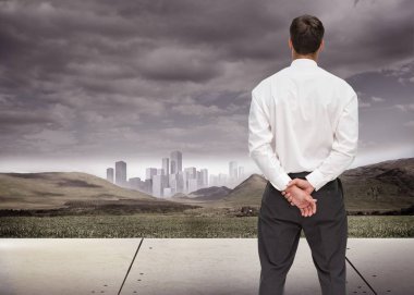 Composite image of businessman turning his back to camera looking at distance city clipart