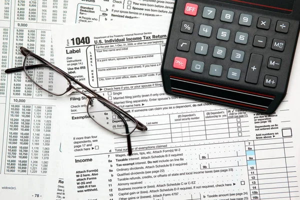 Tax time - Closeup of U.S. 1040 tax return with calculator and glasses