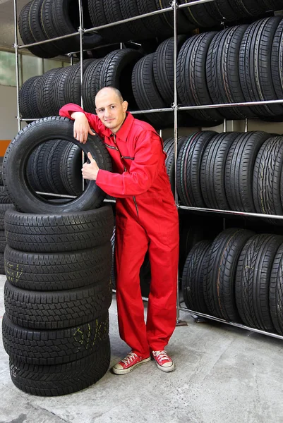 Ein Optimistischer Mechaniker Steht Neben Einem Reifenstapel — Stockfoto