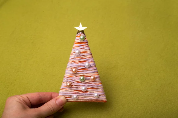 Weihnachtsbaum Aus Fäden Und Perlen Den Händen Hält Das Mädchen — Stockfoto