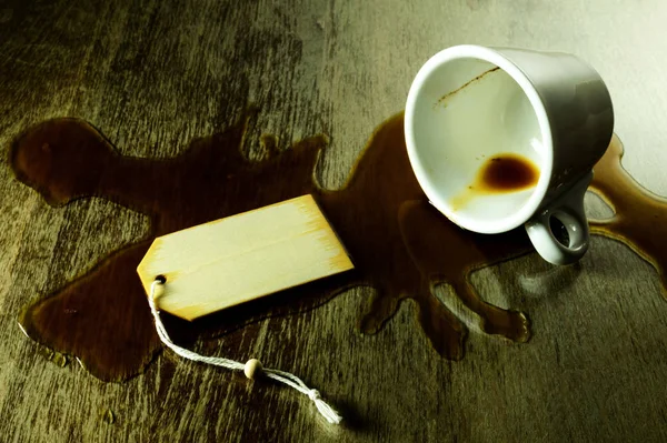 从一个白色的杯子洒咖啡在一个格子桌子上 有文字空间 — 图库照片