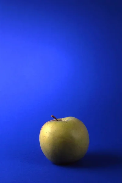 青い背景に隔離された1つの緑のリンゴ — ストック写真