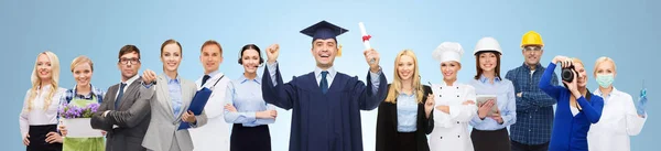 people, profession, education and success concept - happy bachelor with diploma over different workers and blue background
