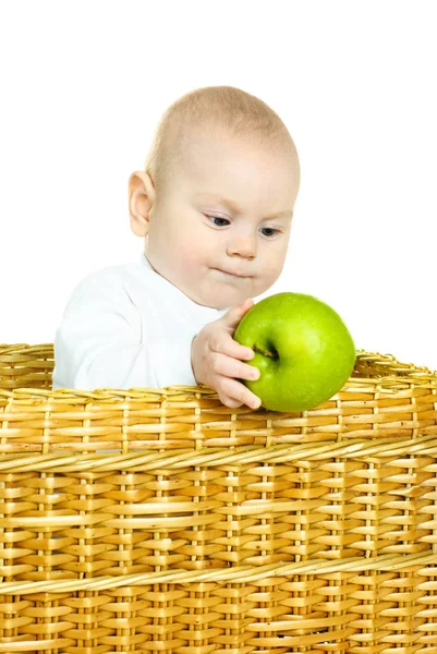 かわいい6ヶ月の男の子がバスケットに座って 緑のリンゴを保持しています — ストック写真