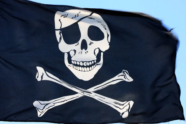 黒い海賊旗が風に揺れ 強風で一部がぼやける — ストック写真