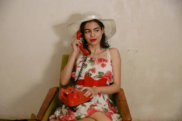 Милая Девушка Кокетливым Взглядом Звонит Кому Ретро Красному Телефону Сидя — стоковое фото