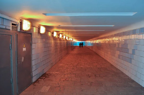 Moscow. An underground passage. The light in the end of the tunnel. On the background of the silhouette of the two.