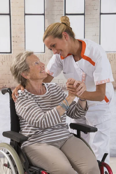 思いやりのある態度で高齢者の女性の手を握って医療看護師 — ストック写真