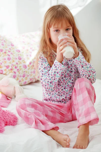 ベッドの中で牛乳を飲む子供の家庭の肖像画 — ストック写真