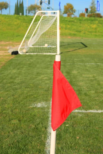 Red corner flag on a soccer field.