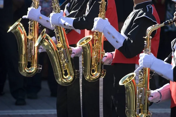 Image of four gleaming saxaphones used by a marching band.