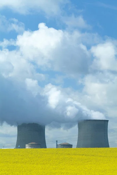 Nuclear Power Station with steaming tower over clear blue sky, France