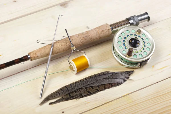 Fly fishing rod and reel with a silver popping bug