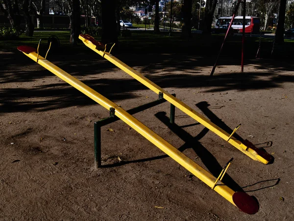 Yellow teeter-totter in a public park