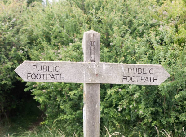 double wooden post public footpath sign outside leading way