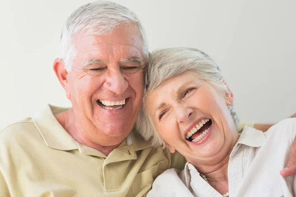 Starsza Para Śmieje Się Razem Domu Salonie — Zdjęcie stockowe