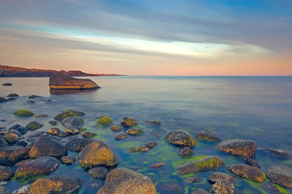 배경ノルウェーの海岸 Moelen の圧延の石に沈む夕日 — ストック写真