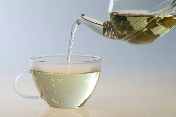 Derramando Chá Para Uma Xícara Chá Transparente — Fotografia de Stock
