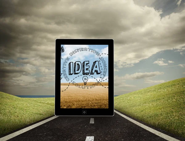 Idea graphic on tablet screen against highway under cloudy sky