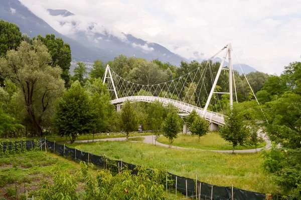 Metal bridge in arc of circle with two arches as support in dolomites in Italy