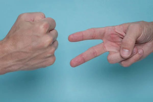 Mannen Handen Spelen Steen Papier Schaar Een Lichtblauwe Achtergrond Een — Stockfoto