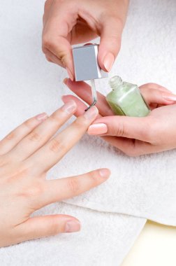 applying manicure: moisturizing the nails and skin around nails clipart
