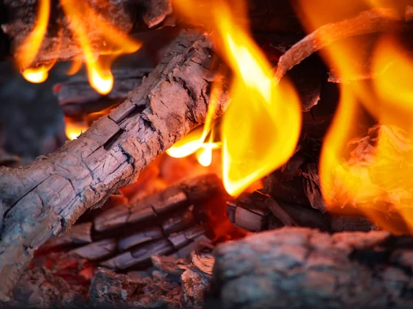 Flames in a fire pit with glowing embers