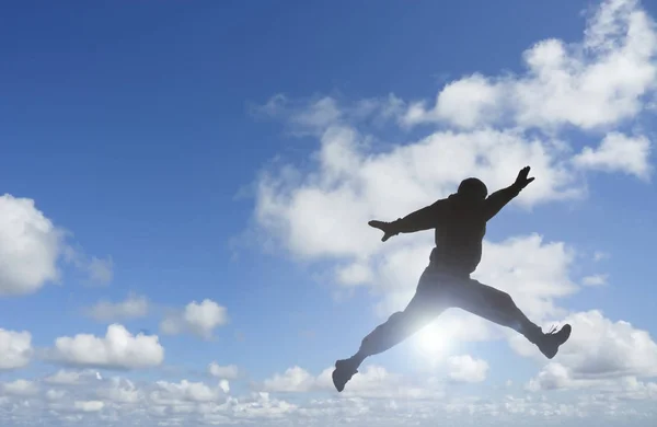 Sziluettje Ember Jumping Meg Kék Felhők — Stock Fotó