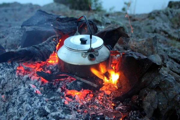 Boiling water in a kettle on a burning bonfire.