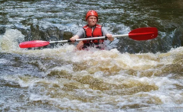 teenager white water kayaking in the rapids