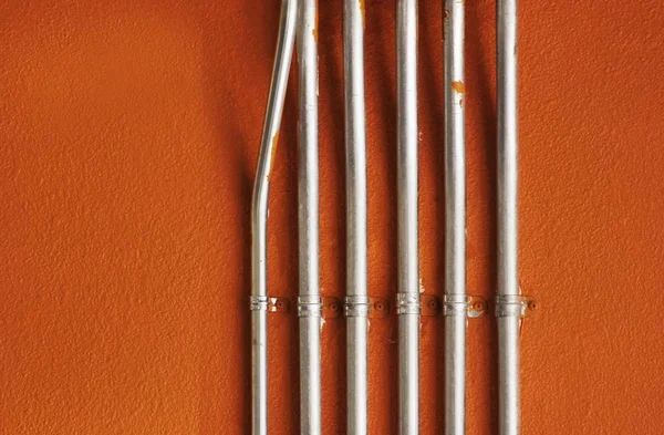 Tubos Utilidad Metal Brillante Montados Una Pared Yeso Pintado Naranja — Foto de Stock