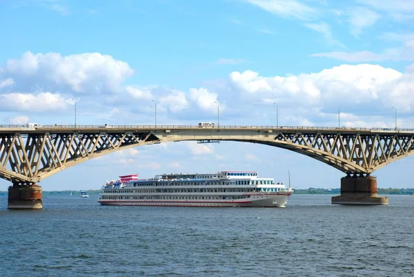 船はサラトフのヴォルガ川を通って橋の下を通過します — ストック写真
