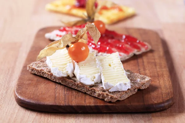 Variety of crisp bread with cheese and jam