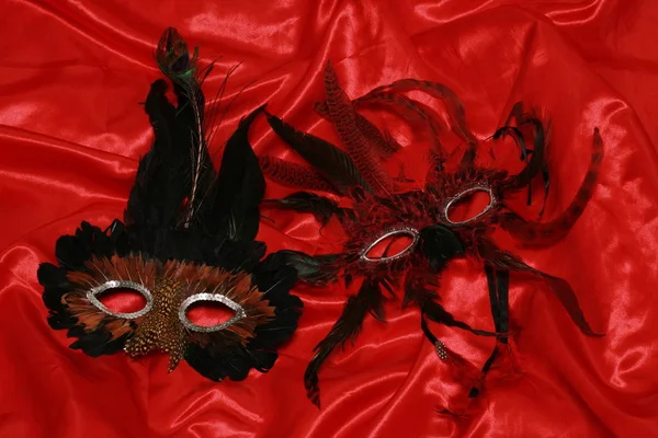 Zwei Karnevalsmasken Auf Rotem Seidenstoff — Stockfoto