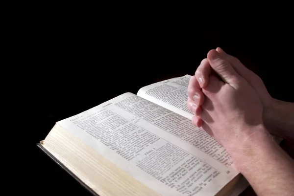 一个人的手紧紧抓住圣经祈祷 — 图库照片
