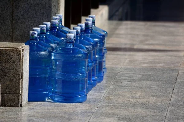 Water bottles waiting to be transported at the side of the pavement