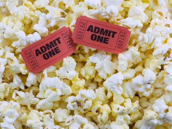 Popcorn close-up with two admit one movie tickets