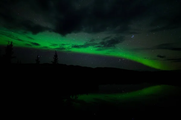 Noční Obloha Hvězdy Mraky Northern Lights Zrcadlena Klidné Jezero Yukon — Stock fotografie