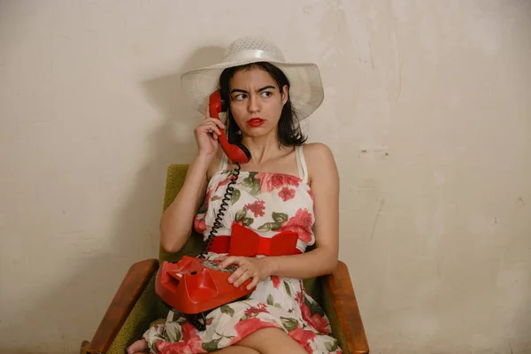 Симпатичная Девушка Серьезным Взглядом Звонит Кому Ретро Красному Телефону Сидя — стоковое фото