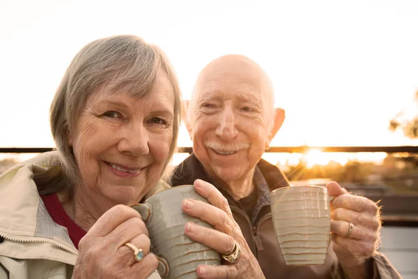 快乐的老夫妇坐在户外喝咖啡 — 图库照片
