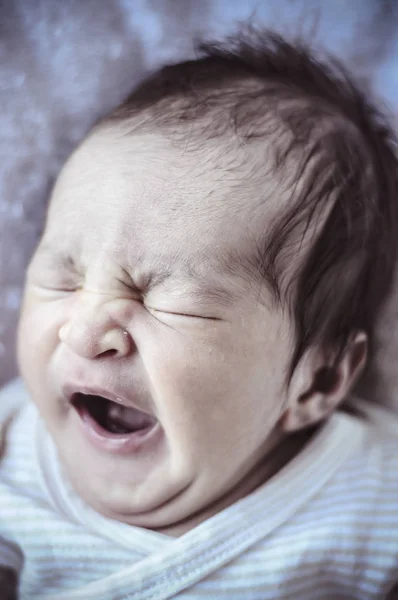Yawn, new born baby curled up sleeping on a blanket, multiple expressions