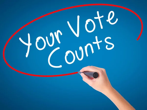 Women Hand writing Your Vote Counts with black marker on visual screen. Isolated on blue. Business, technology, internet concept. Stock Image