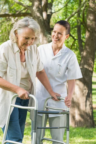 Sorridente Giovane Donna Che Assiste Donna Matura Con Walker Parco — Foto Stock