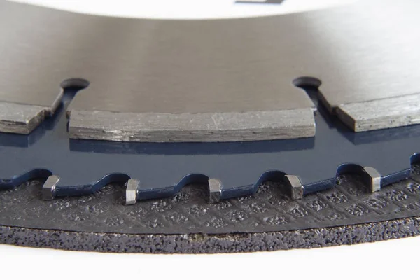 An abrasive blade, a carbide tipped saw blade and a diamond concrete saw blade stacked up on one another.