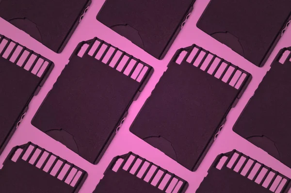 Close up on several sd cards arranged in a parallel pattern with pink filter