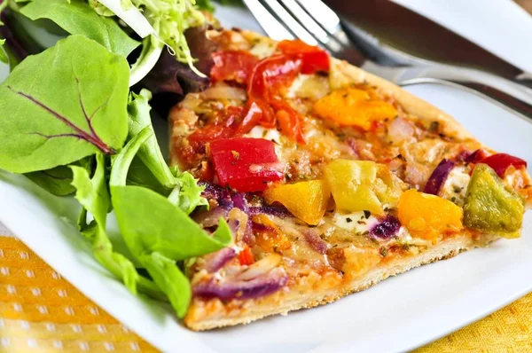 Vegetarian meal of vegetable pizza and green salad