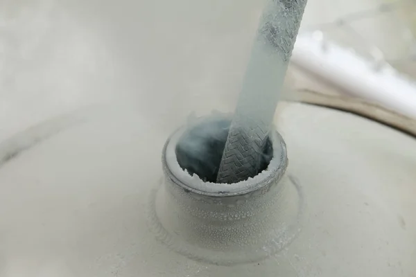 Close up of container with liquid nitrogen,Cold metal pipe smoking from transferring liquid nitrogen