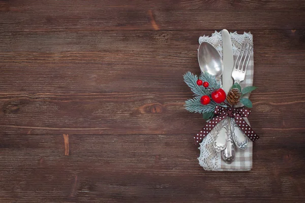 Christmas silver table set. Old wooden background. Crocheted napkin.