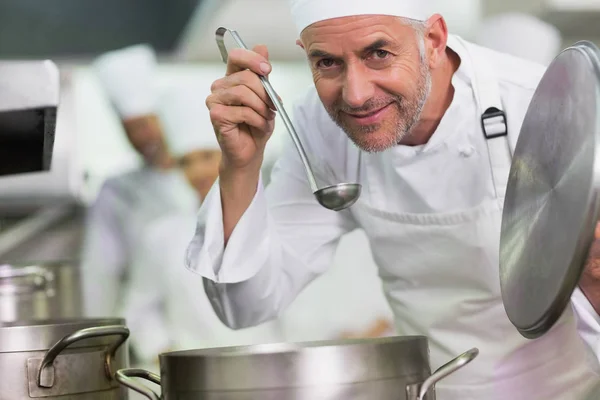 Шеф Повар Нюхающий Суп Улыбающийся Камеру Коммерческой Кухне — стоковое фото