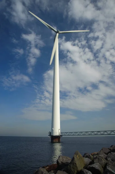 站在蓝天下的海上的风力涡轮机 — 图库照片